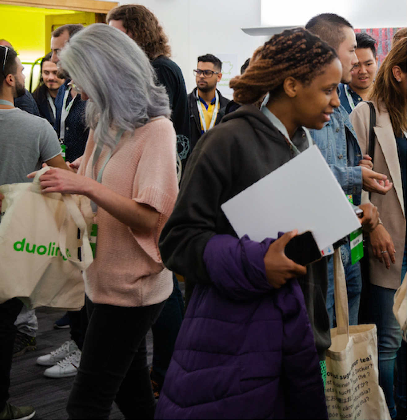 Participants chatting with Duolingo tote bags