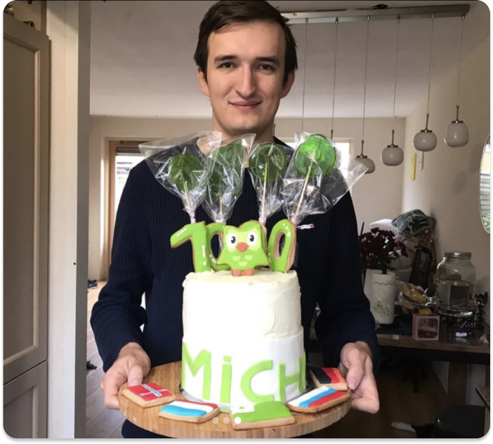 A Duolingo fan holding a tray with a cake celebrating a 1000-day streak